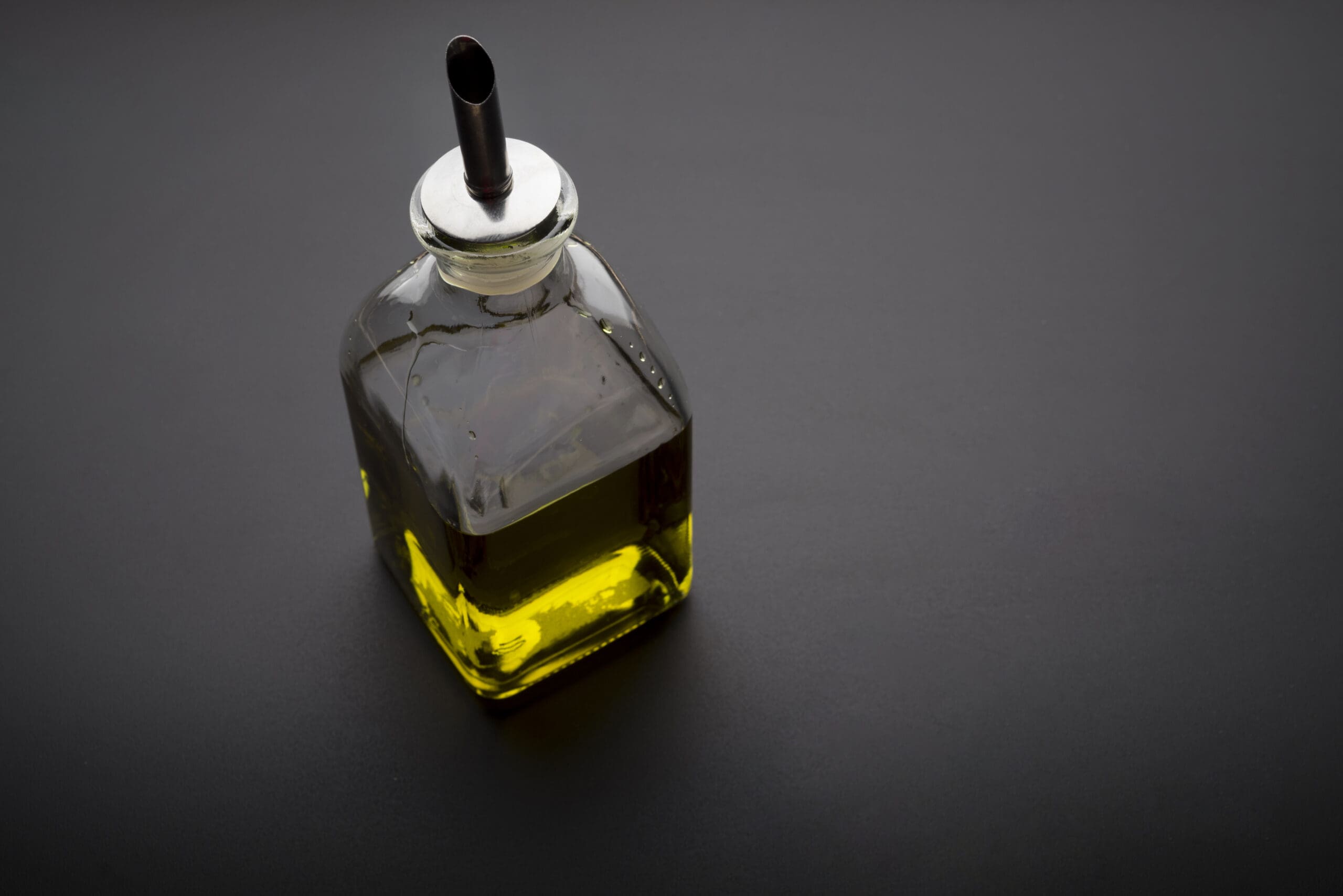bottle olive oil dark background scaled