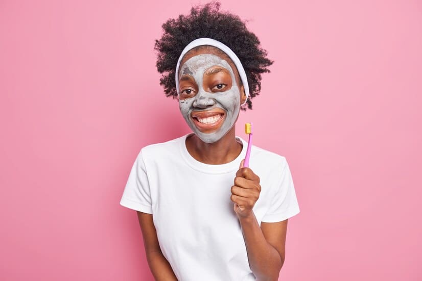 photo glad millennial girl with afro hair smiles pleasantly applies clay mask holds toothbrush 273609 52052